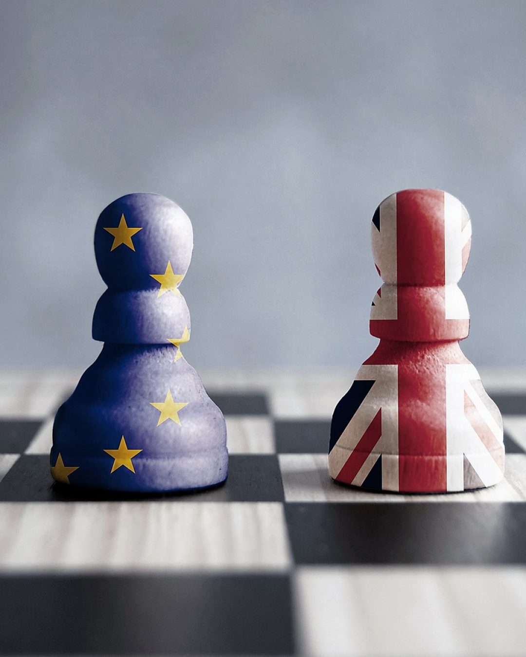 Two chess pawns with UK and European flags